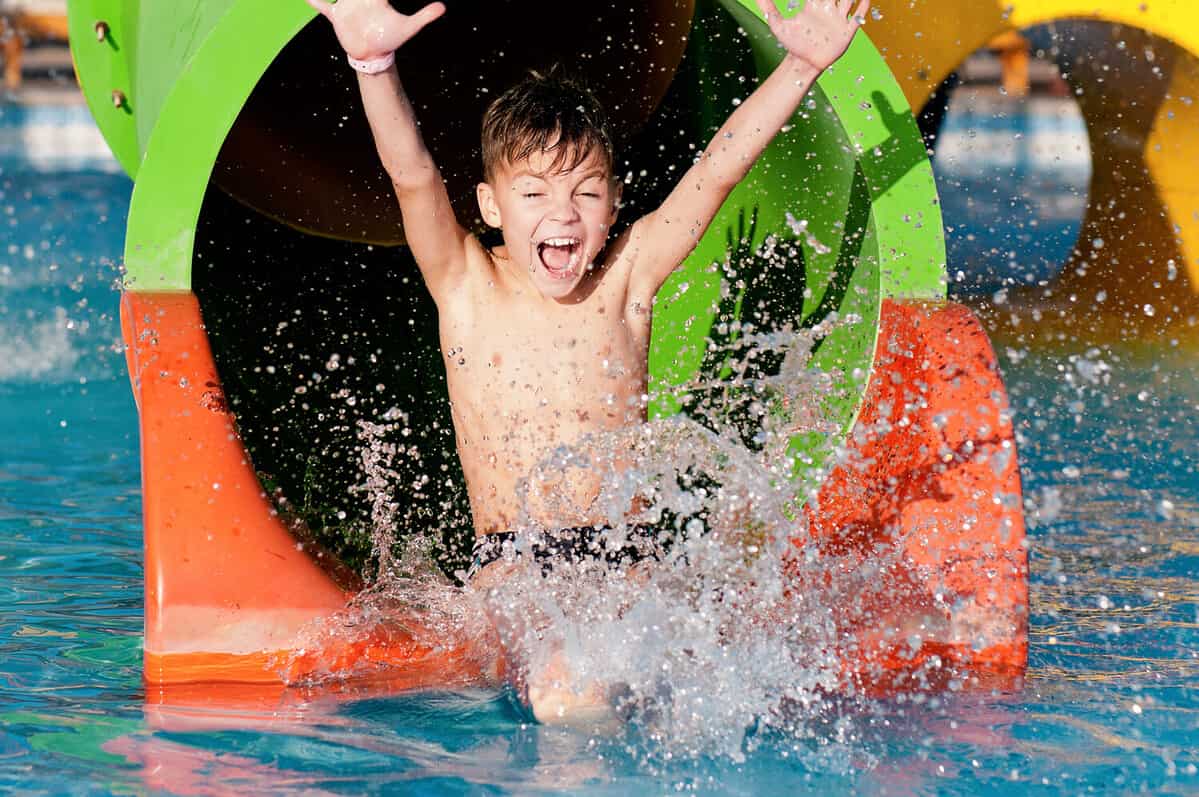 Boy has into pool after going down water slide during summer