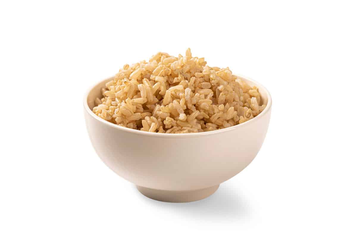 Brown rice in white cup isolated on white background.