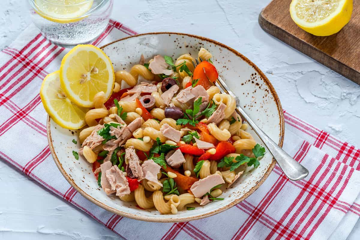 Warm pasta salad with tuna, roasted red pepper and pine nuts