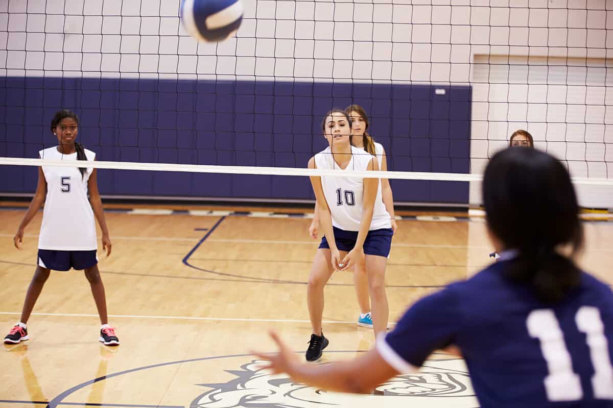 High School Volleyball Match In Gymnasium