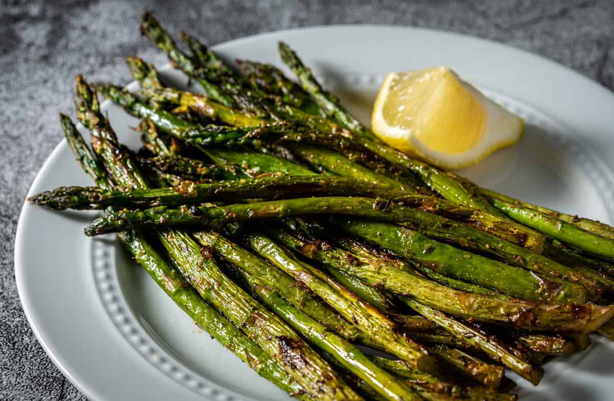 Grilled asparagus on white serving dish.
