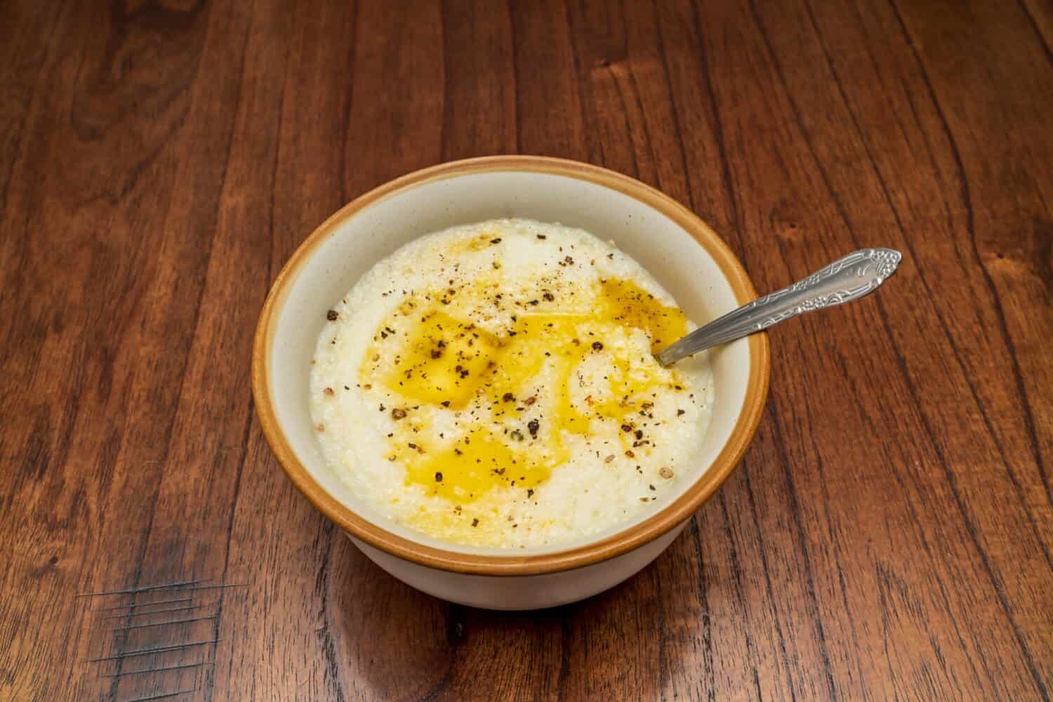 A delicious bowl of grits with melted butter and freshly cracked pepper