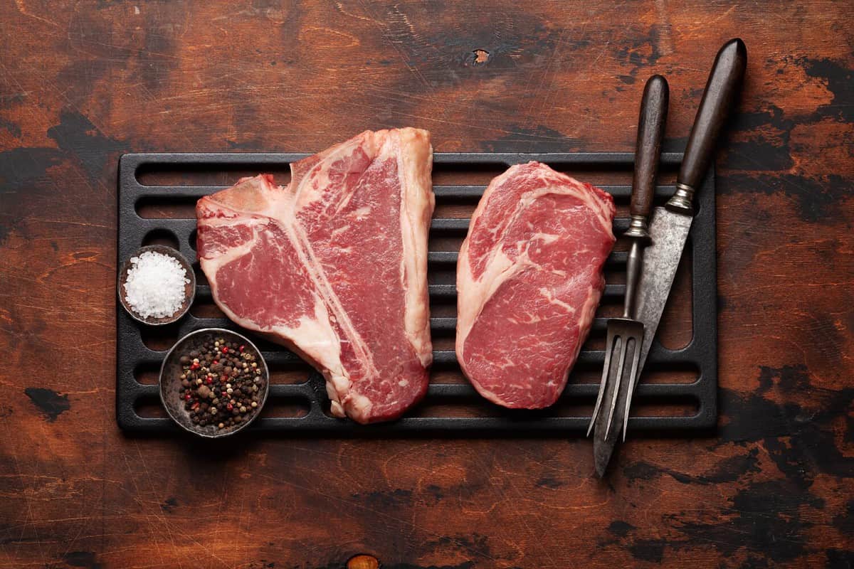 Various raw beef steaks. Porterhouse and ribeye. Top view flat lay