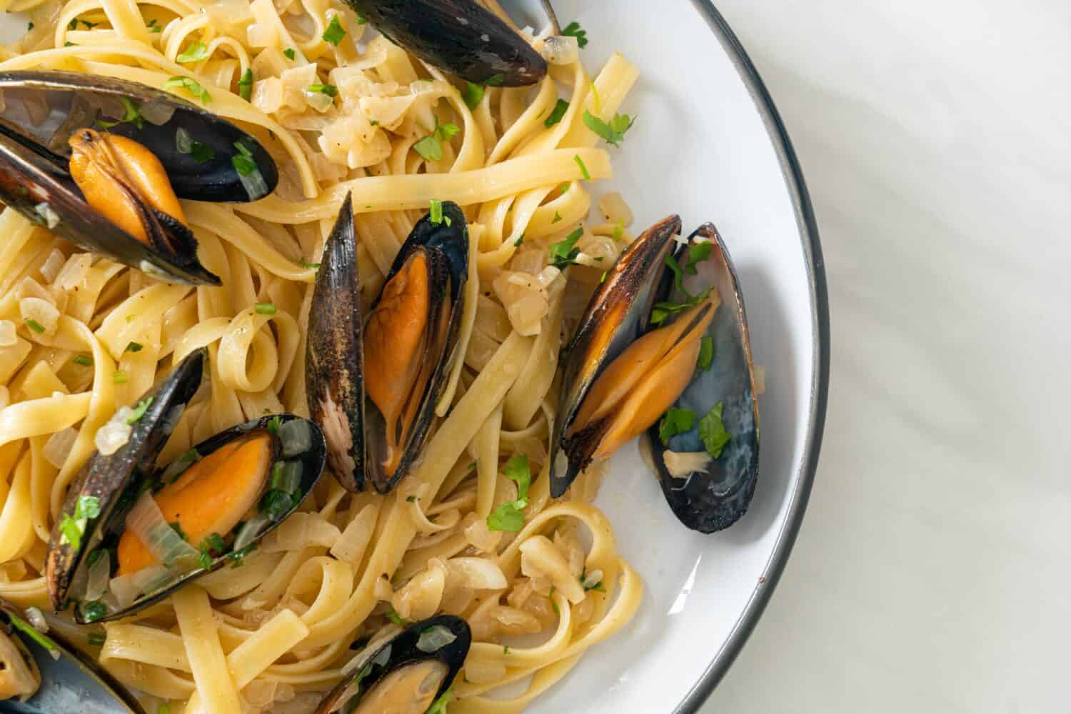 linguine spaghetti pasta vongole white wine sauce - Italian seafood pasta with clams and mussels