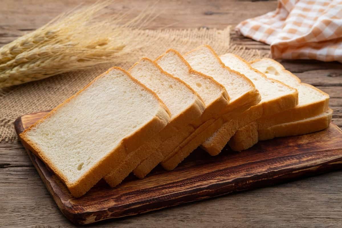 Sliced white bread on wooden board