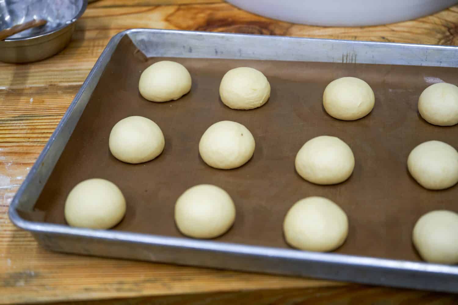 Small dough for kneaded smooth bread on a baking sheet