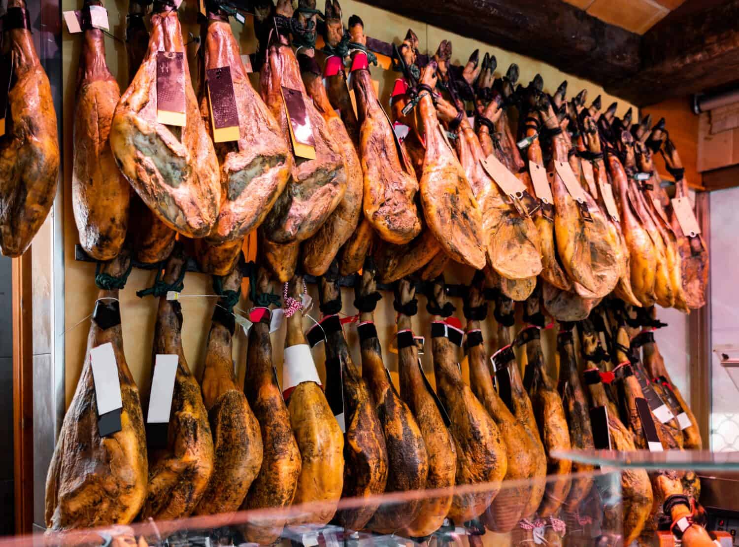 Legs of traditional Spanish jamon ready for sale in grocery