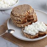 Rye bread and a sandwich with cottage cheese on a white table
