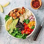 Mexican chicken burrito bowl with rice, beans, tomato, avocado,corn and lettuce.