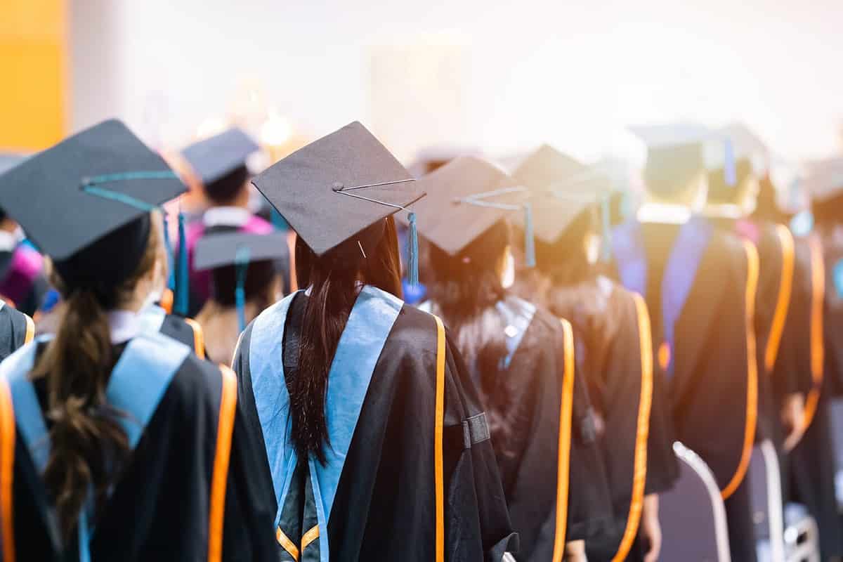 Rearview of university graduates wearing an academic gown on commencement day. Education stock photo