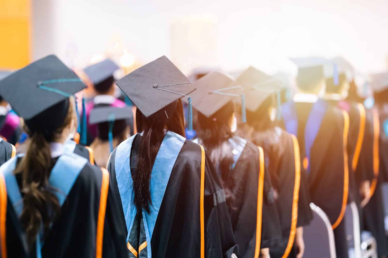 Rearview of university graduates wearing an academic gown on commencement day. Education stock photo