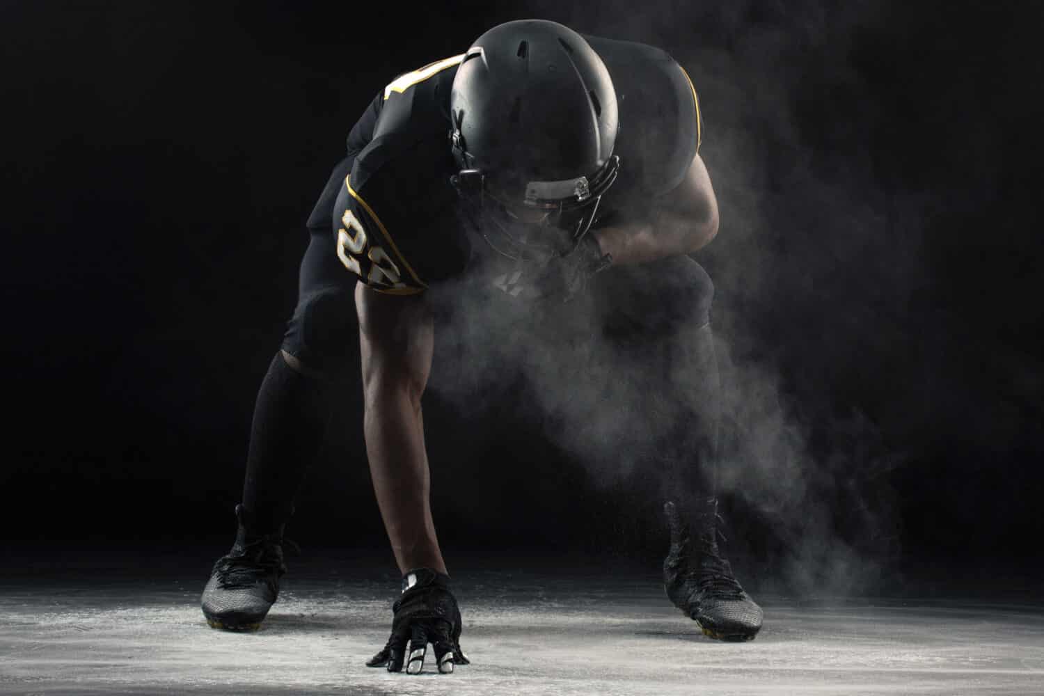 African American football player in a three points stance.