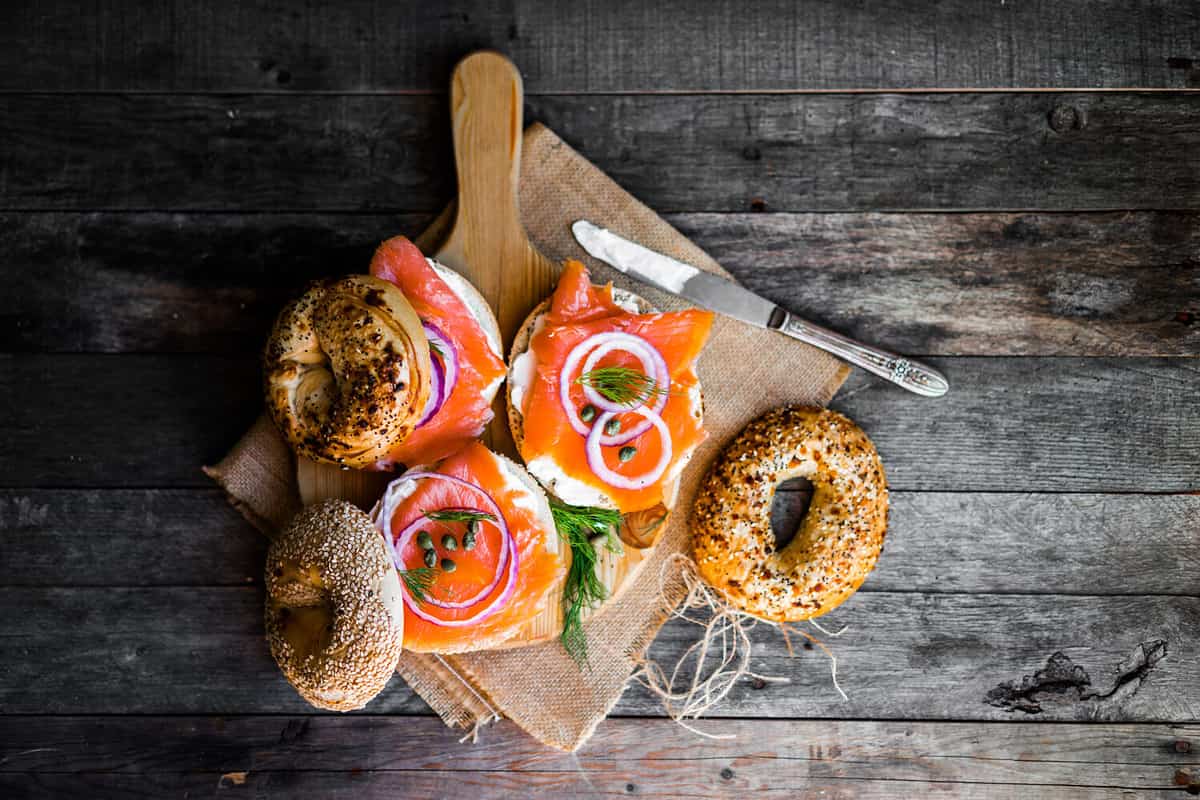 Bagels with cream cheese and smoked salmon on rustic wooden background