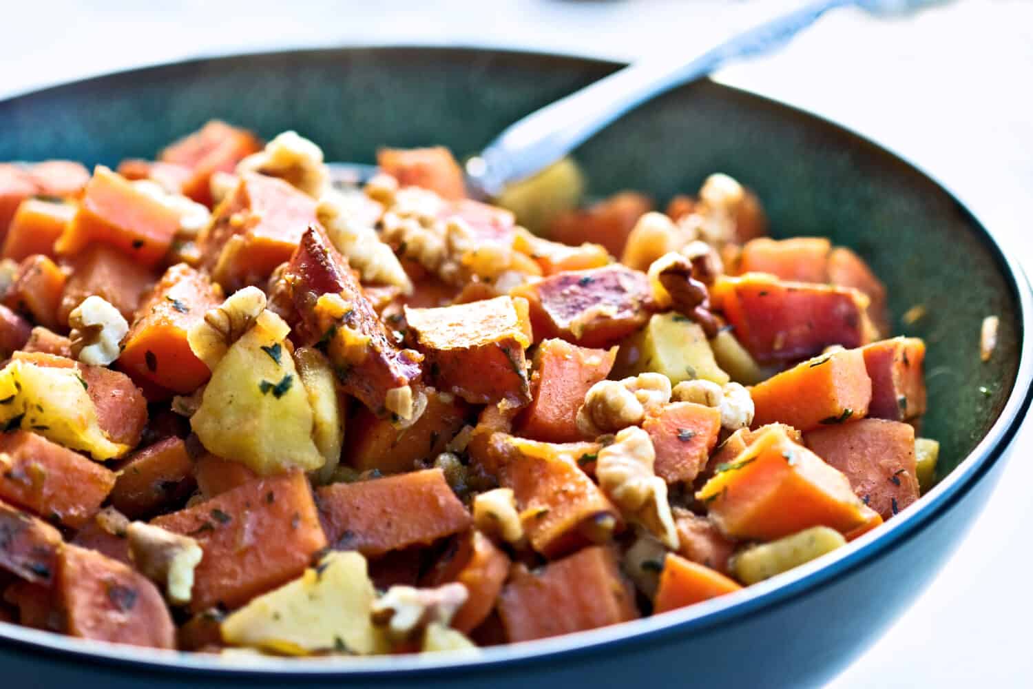 Sweet potato hash, a perfect dish for the holidays. Diced sweet potatoes fried with apples and seasoned with parsley and walnuts.