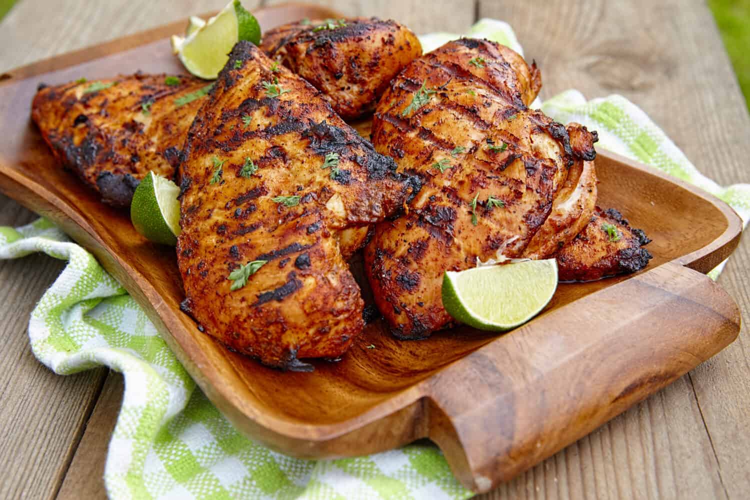Grilled chicken breast served with herbs and lime