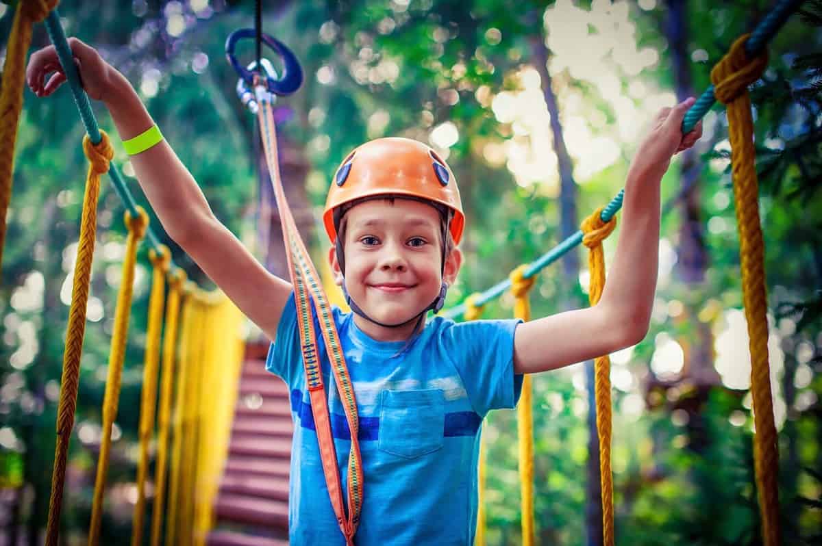 happy boy on the zip line. proud of his courage the child in the high wire park. HDR