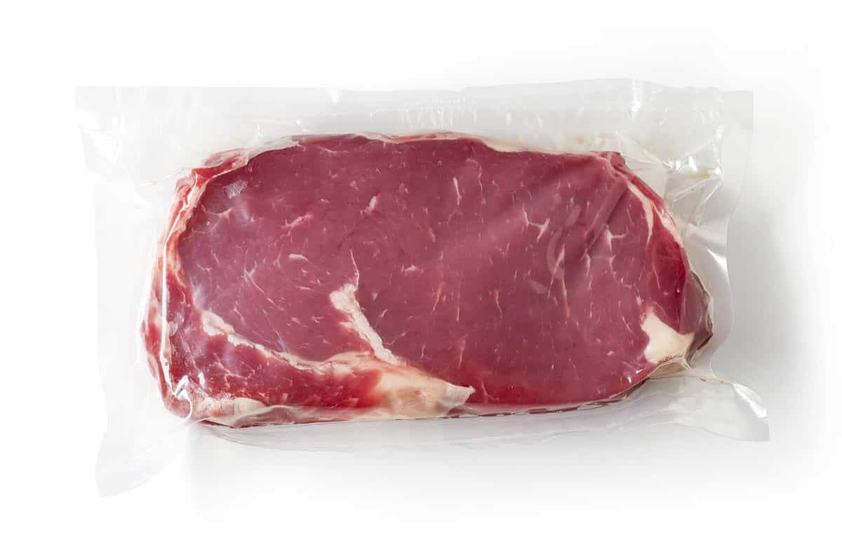 Vacuum sealed fresh beef steak for sous vide cooking isolated on white background, top view