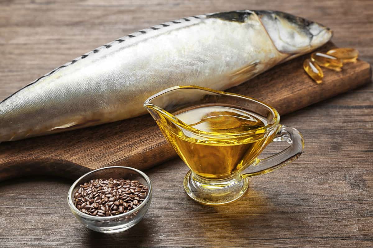 Fish oil with flax grain and fish on wooden background