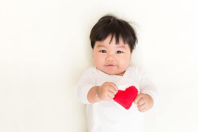 Red heart with adorable asian baby girl for valentine concept background and copy space.