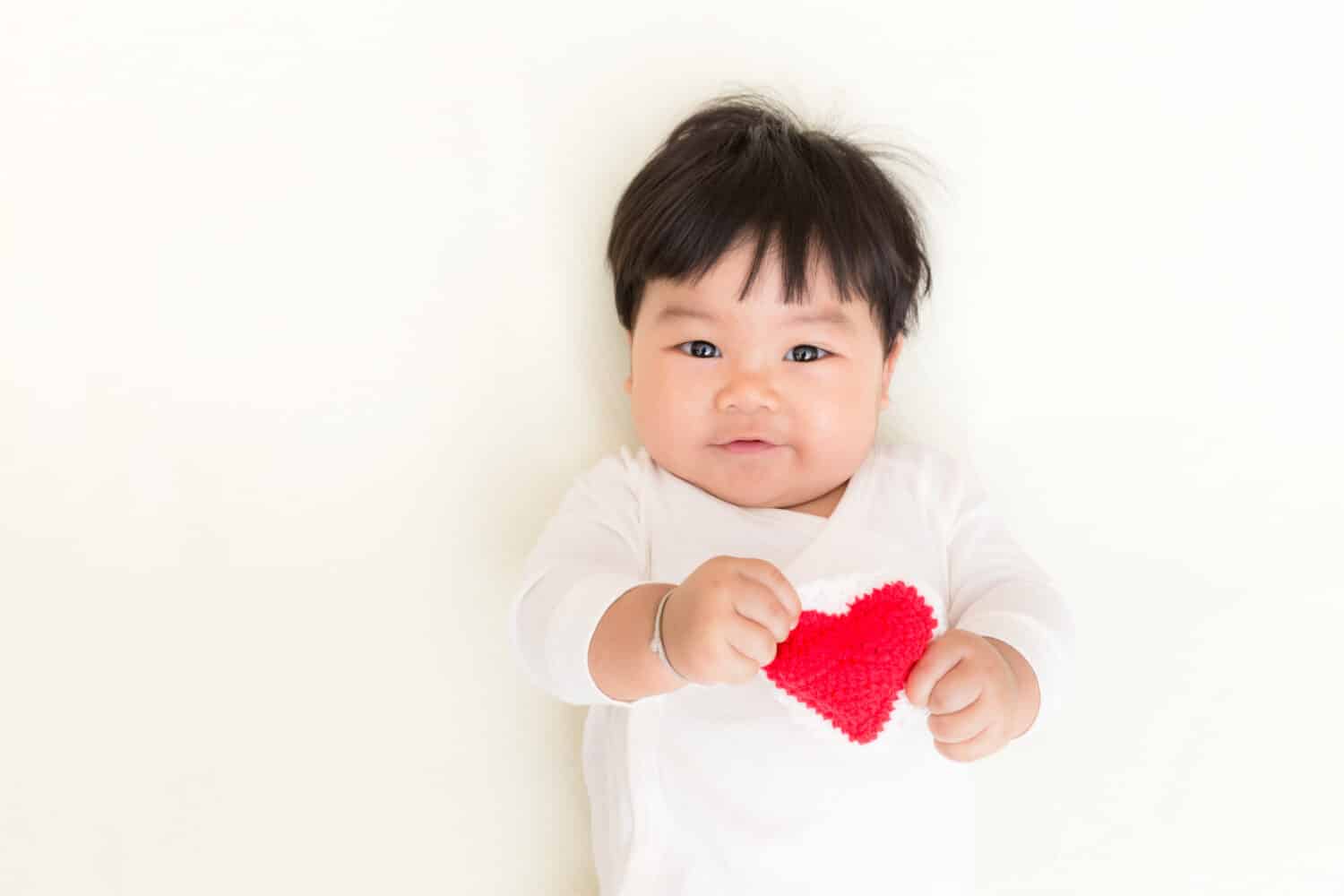 Red heart with adorable asian baby girl for valentine concept background and copy space.