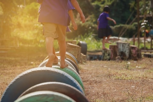 Kids playing in the playground. Running on tires.selective focus