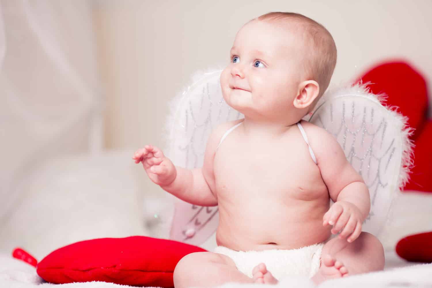 Portrait of little beautiful baby in an angel costume. Valentine's Day.