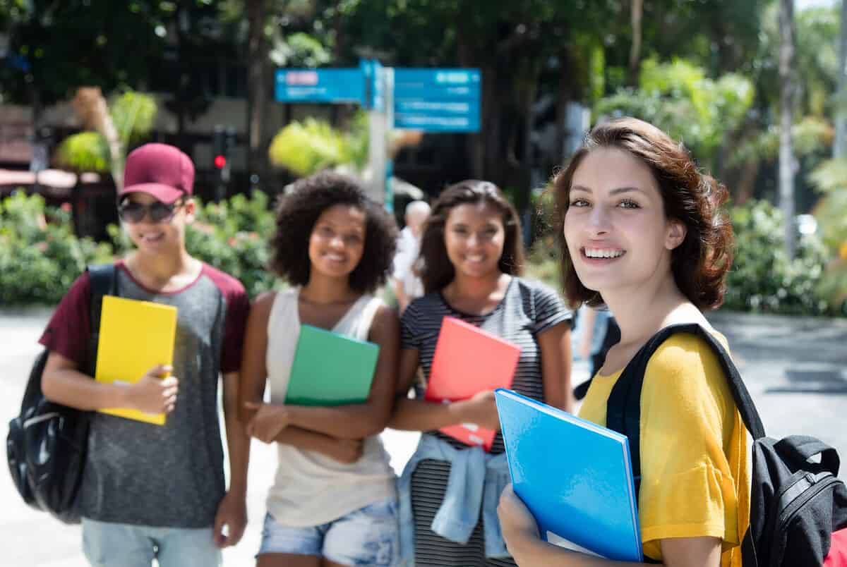 Happy caucasian female student with group of international students