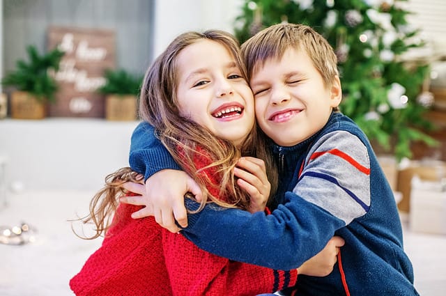 Funny kids are hugging. The boy and the girl. Happy Christmas and New Year Concept.