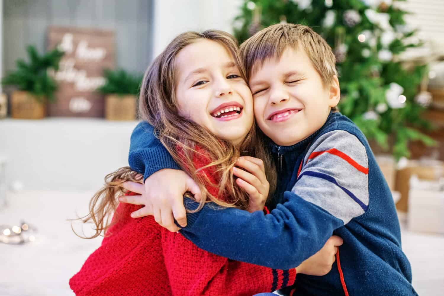 Funny kids are hugging. The boy and the girl. Happy Christmas and New Year Concept.