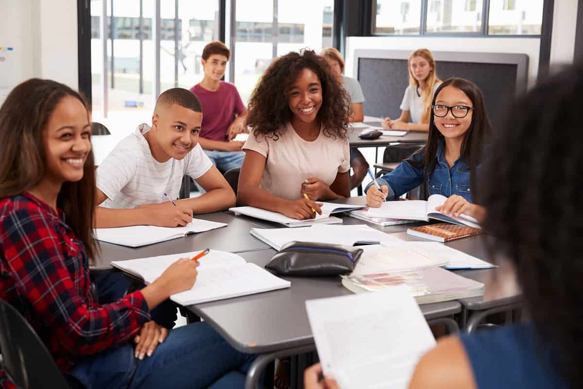 A bunch of high school kids seated at a table. 