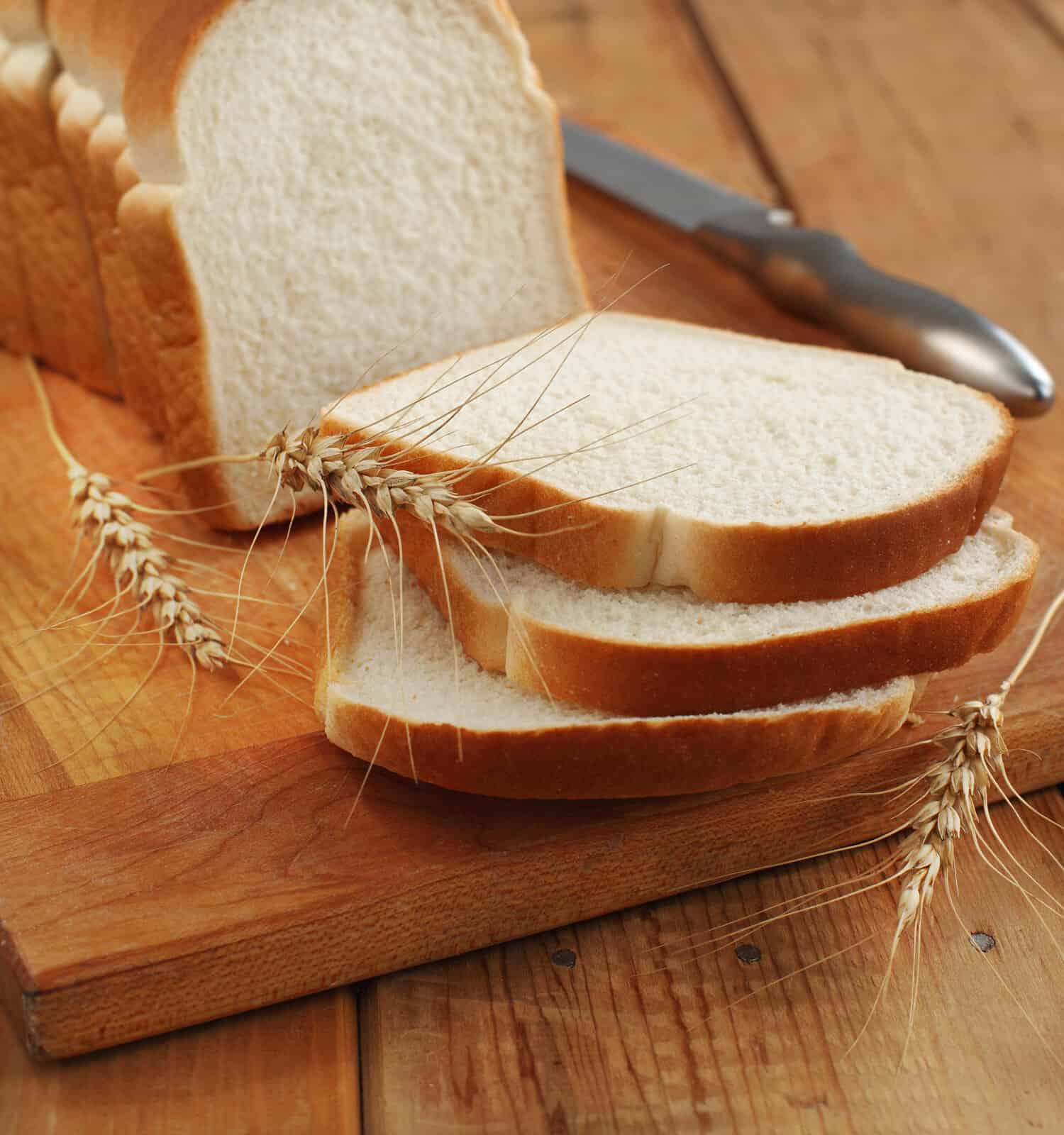 White bread vs. wheat bread: White bread sliced on a cutting board
