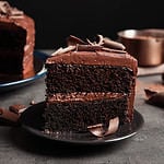 Plate with slice of tasty homemade chocolate cake on table