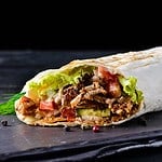 Traditional Mexican food, burritos with meat and beans, selective focus of beef steak burritos with vegetable