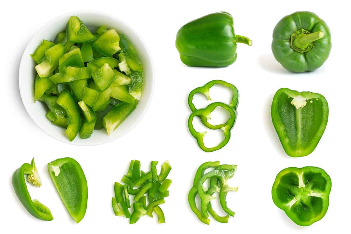 Set of fresh whole and sliced green bell pepper isolated on white background. Top view.