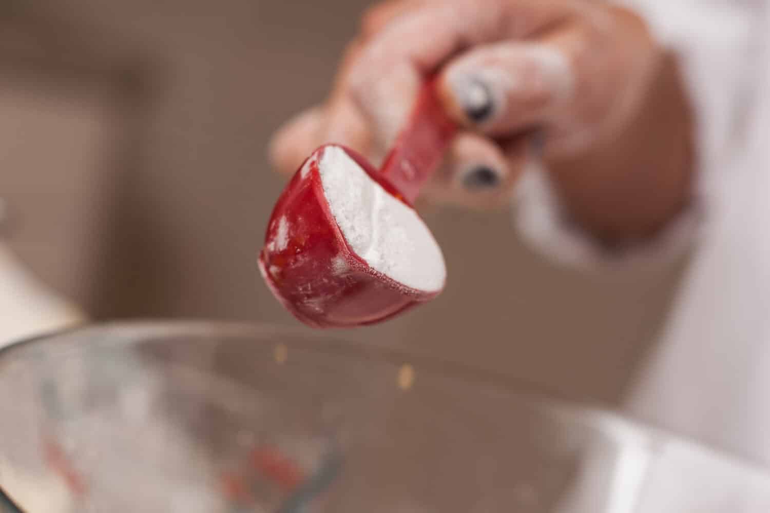 Gourmet chef pouring baking powder into bowl