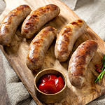 Grilled sausages with spices on a wooden serving Board