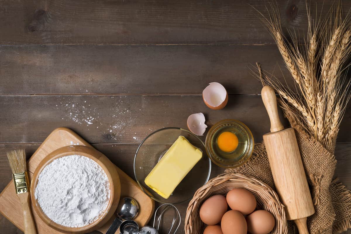 Bread flour with fresh egg, Unsalted butter and accessories bakery on wood background, prepare for homemade bakery concept