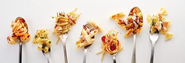 Various types of yummy pasta on spoons and forks (carbonara, spaghetti bolognese, pasta penne arrabiata, fusilli pasta bolognese)