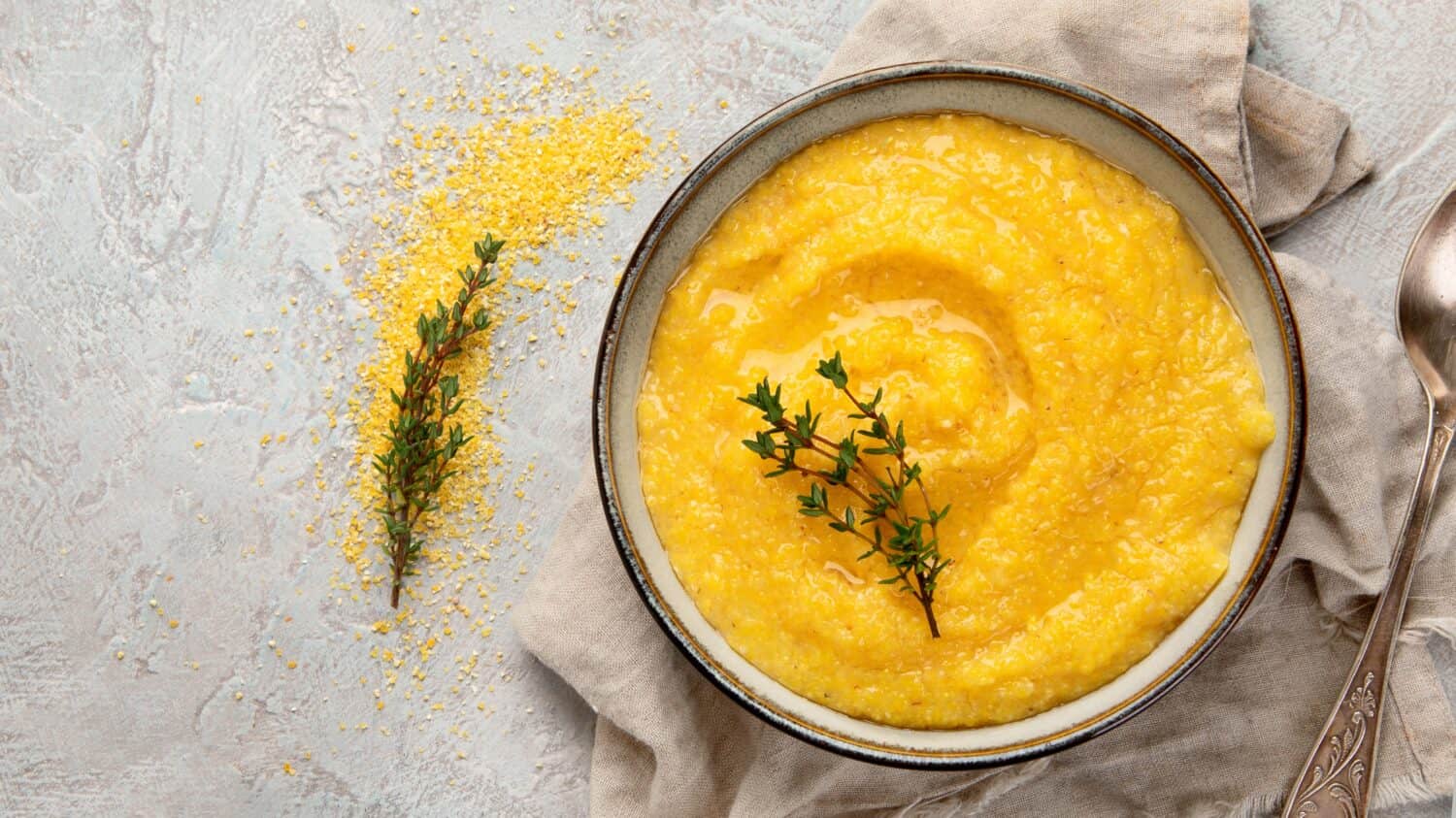 Corn polenta on gray background. Healthy food concept. Top view flat lay, copy space