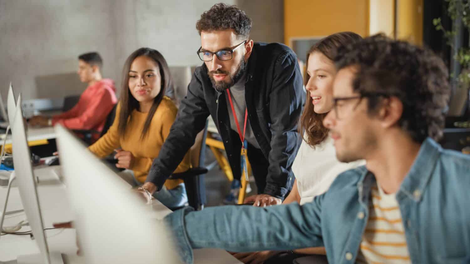 A lecturer helping his students understand a computer program.