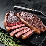 Grilled top sirloin or cup rump beef meat steak on marble board. Black background. Top view