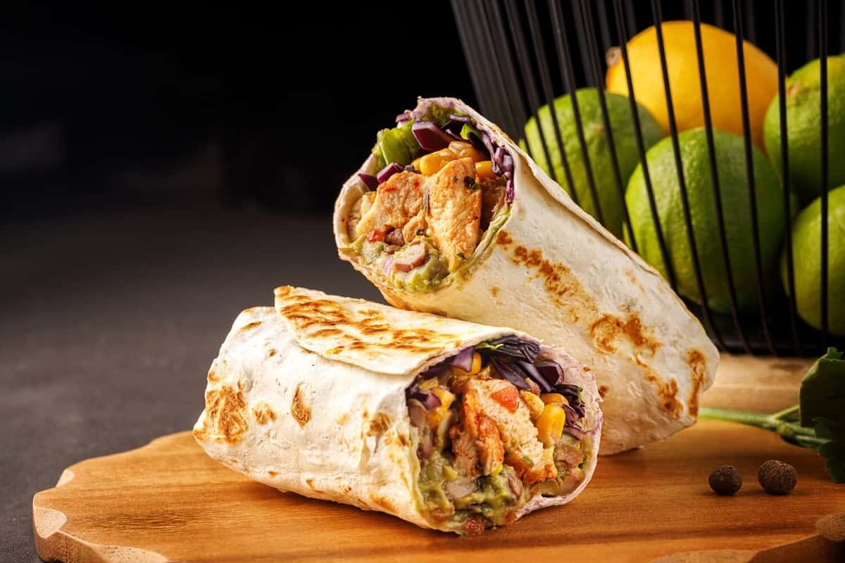 Chicken Burrito Burritos with chicken and vegetables at wooden desk close up