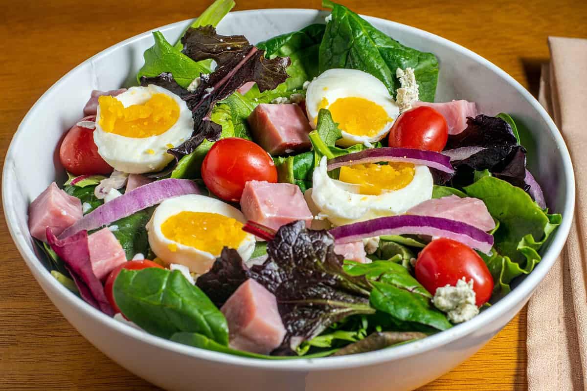 chef salad of tomatoes . hams and tomatoes with mixed greens