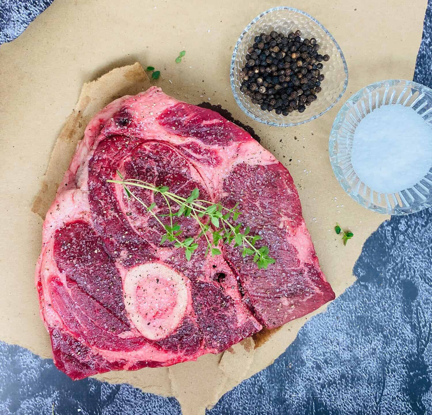 Raw Beef arm roast with kosher salt and black peppercorns