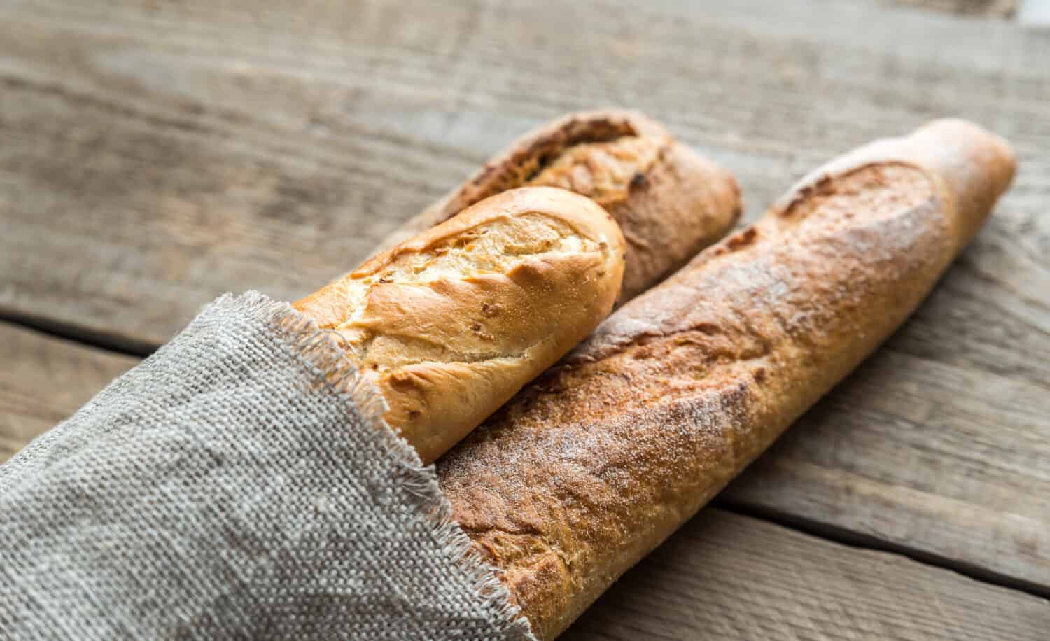 Three baguettes on the wooden background