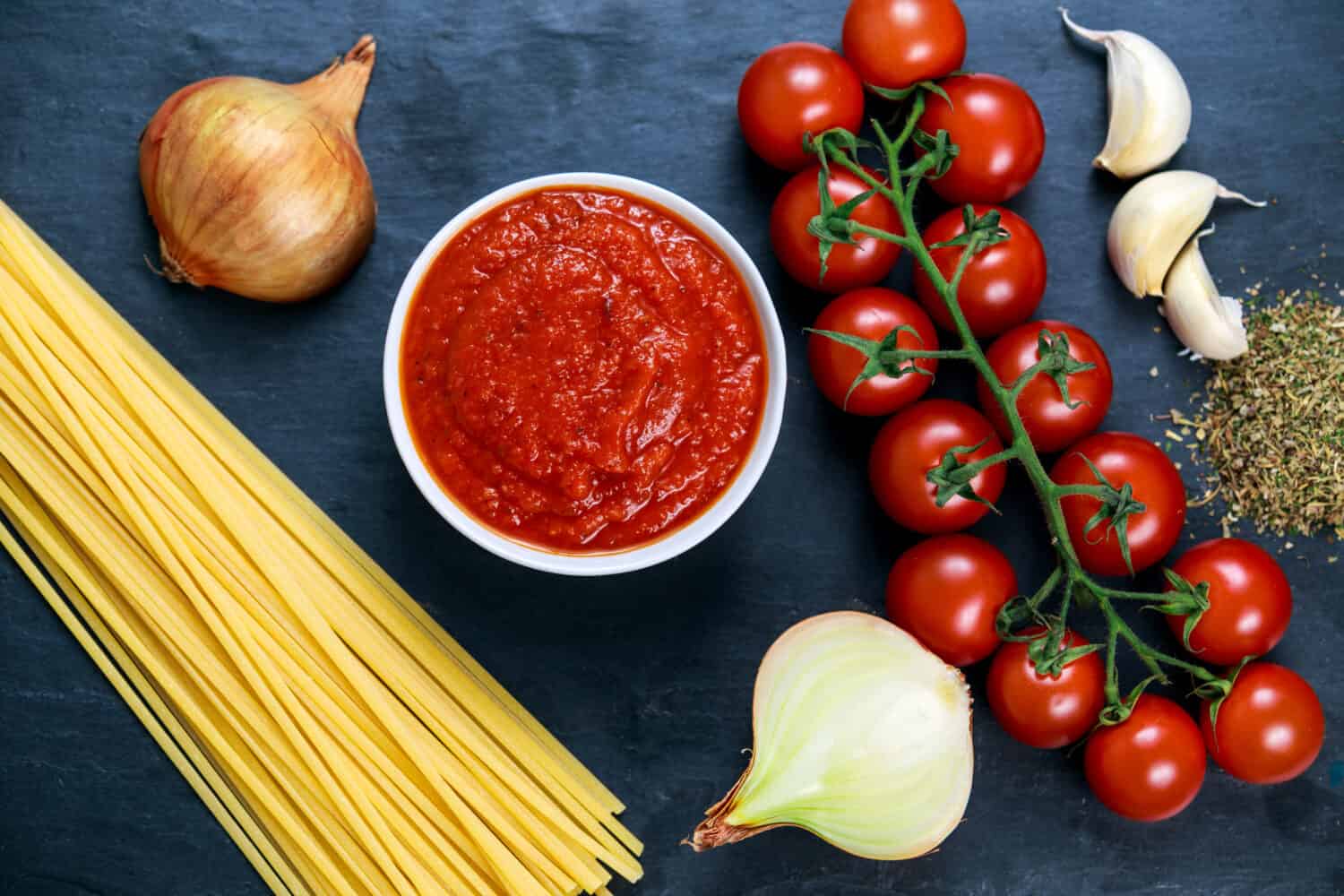 Ingredients for Spaghetti with marinara sauce.  Ready to Cook. On blue background.