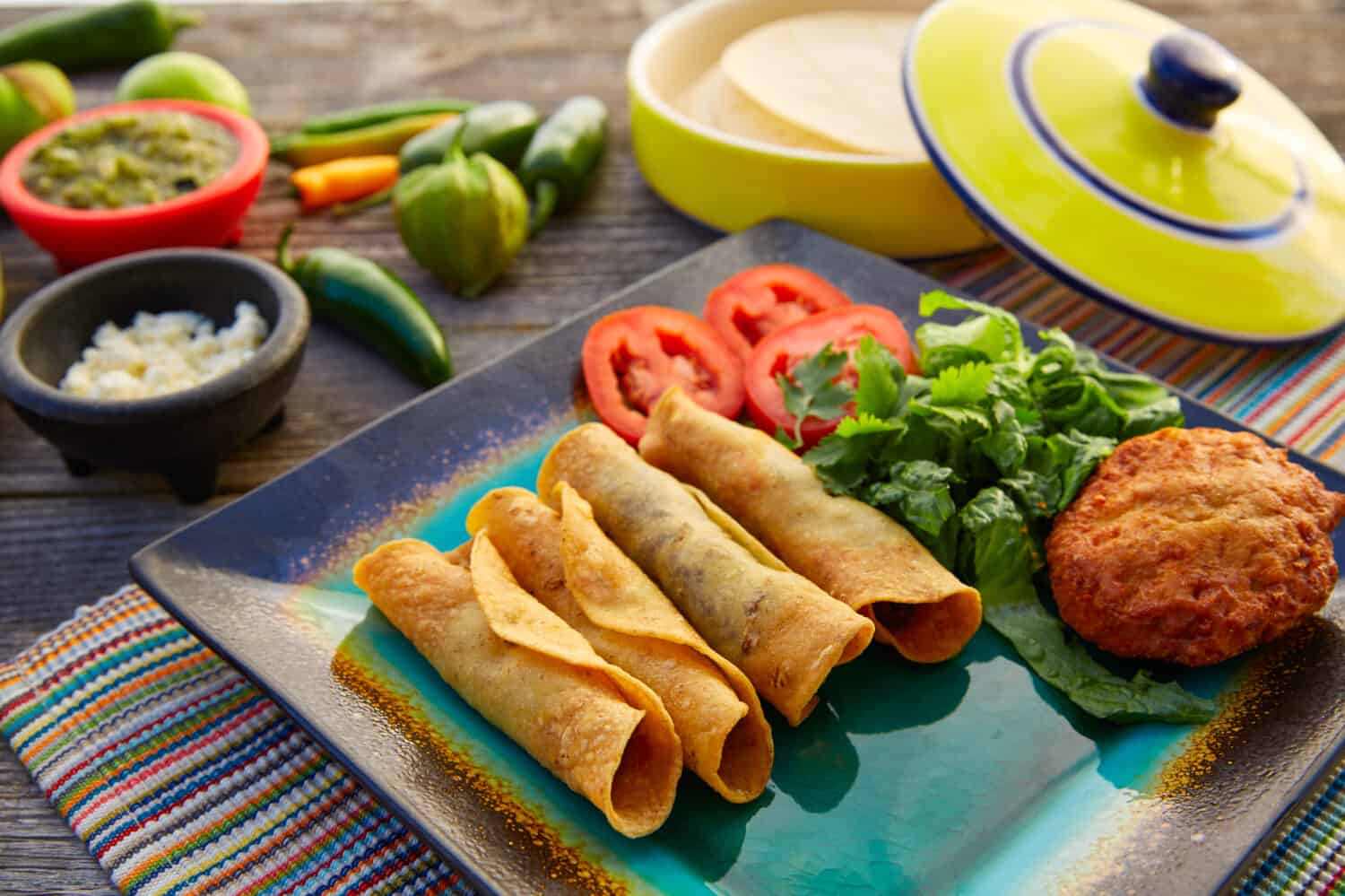 Mexican flautas rolled tacos with salsa and Mexico food ingredients