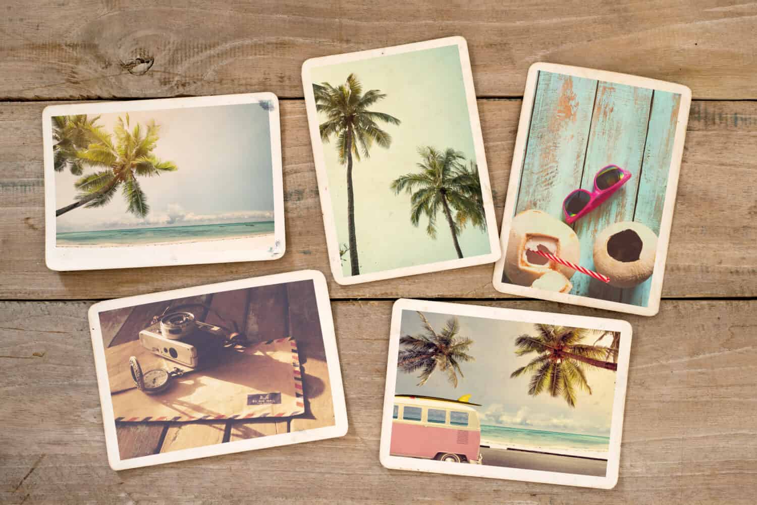 Summer photo album of remembrance and nostalgia on wood table. Photography from beach vacation. instant photo camera - vintage postcards and retro styles