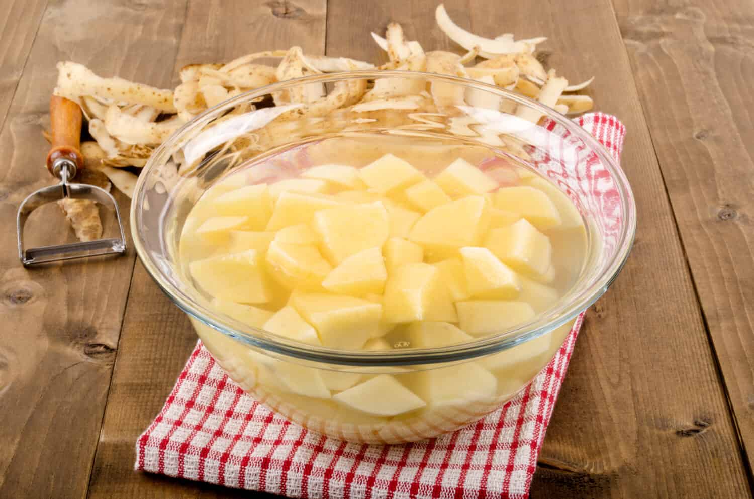 diced potatoes in a glass bowl with water to remove the potato starch