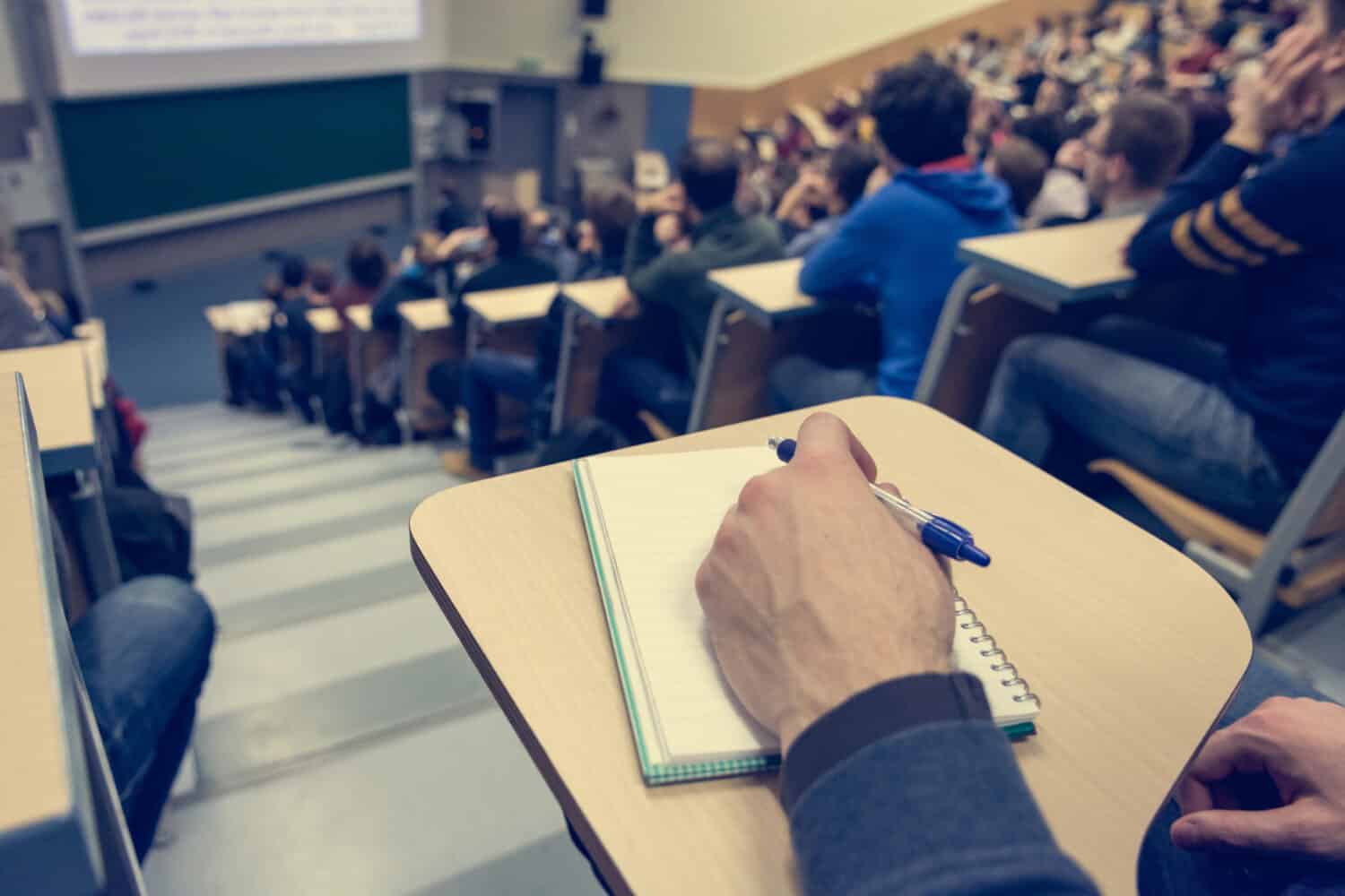 A university lecture hall with students taking notes.